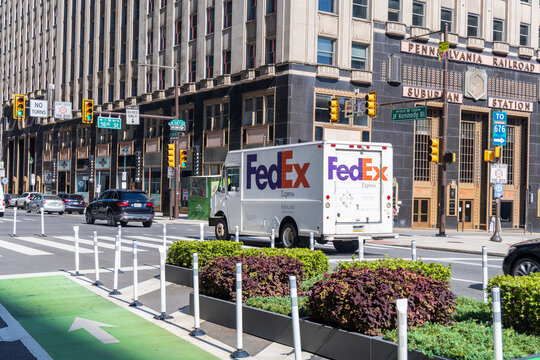 A Fedex truck is driving down a city street