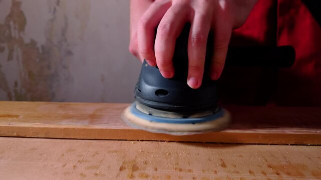 Carpenter uses grinder disc to remove unevenness on surface