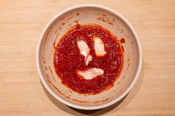 Pasta sauce within a face of mozzarella in a bowl.