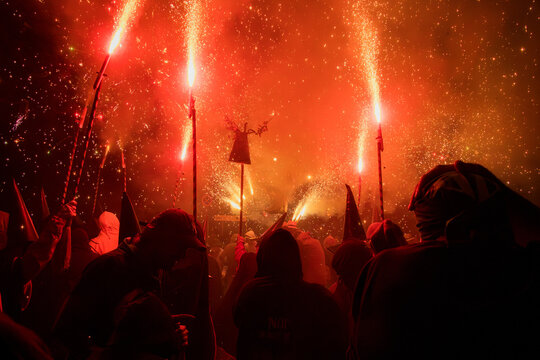 Group of demons that are part of a popular Catalan festival, with long sticks and strong firecrackers at the end, filling everything with fire and smoke,