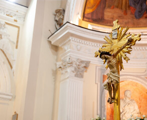 Golden crucifix inside a church representing jesus christ on the cross