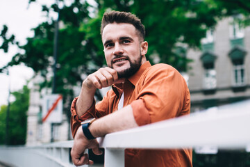 Smiling bearded guy leaning on railing