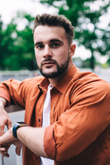 Serious male standing near road