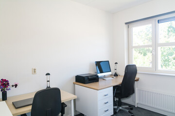 Home office space with furniture and office supplies to work. Window with a view .