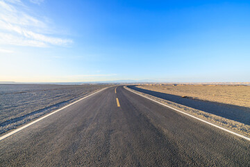 Asphalt highway road and desert sand natural landscape under the blue sky. Car background.