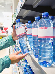 Bottles of rinking water in hand at shop