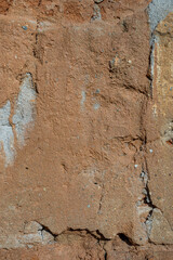 old brick wall plastered with clay sand and lime, washed by the rain