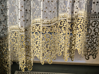 Delicate lace curtains with intricate patterns gently draping the window, letting in soft light,...