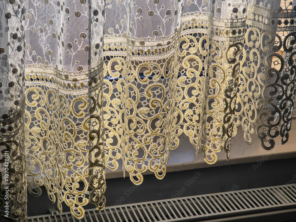 Poster a close-up view of intricately designed lace curtains in warm sunlight, highlighting the delicate pa
