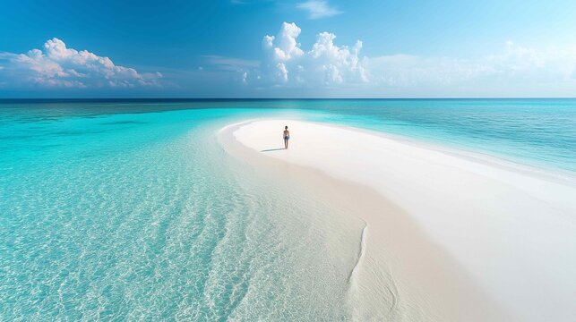 A solitary figure walking on a vast empty beach
