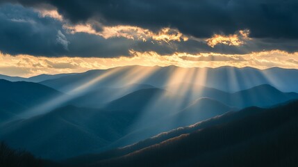 The first rays of sunlight break through the clouds over a mountain range, casting long shadows