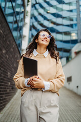 Young businesswoman going to work in front of modern business building	