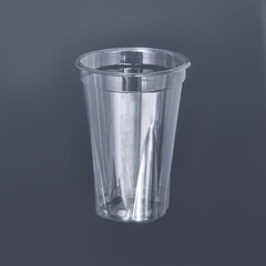 Photo of a disposable clear plastic cup on a dark background. Subject photography.