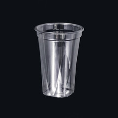 Photo of a disposable clear plastic cup on a dark background. Subject photography.