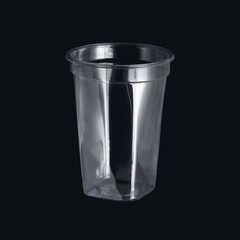 Photo of a disposable clear plastic cup on a dark background. Subject photography.