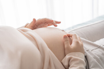 Pregnant woman holds hands on belly touching her baby caring about her health Beautiful happy pregnant woman .tender mood photo of pregnancy.