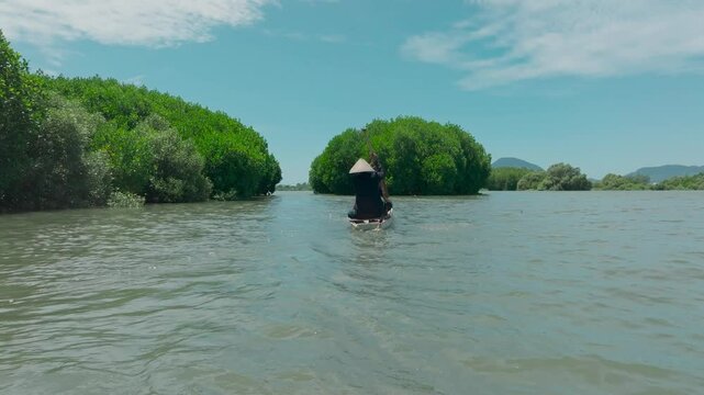 Aerial view of asian fishermen row their boat through the mangrove ecosystem waterways