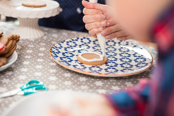 Hand decorating cookie with icing from piping bag
