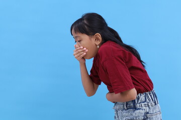 Asian little girl feel nauseous and will vomit. Healthy concept. Isolated on blue with copyspace