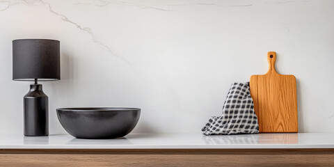 Stylish kitchen countertop featuring modern bowl, lamp, and wooden cutting board in serene setting
