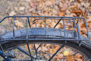 one black metal trunk above the wheel of a sports bike on the street on a brown background