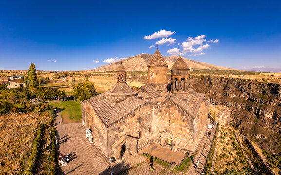 Aerial top view of Saghmosavank Monastery (13h centuries) is located huge gorge canyon of Kasakh River. Church and Mount Ara on beckground in sunny summer day. Saghmosavan, Aragatsotn, Armenia, Europe