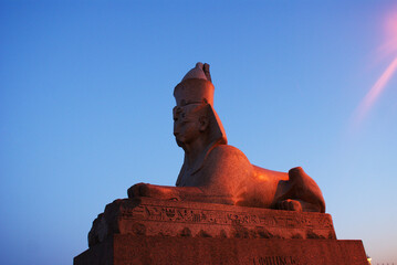 Egyptian sphinx made of granite stone against the sunset, sculpture.