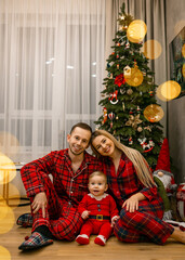 Happy family in matching pajamas celebrating Christmas at home