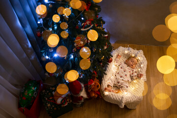 Peaceful baby sleeping under beautifully decorated Christmas tree