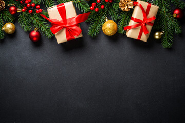 Black christmas flat lay background. Christmas tree with present box and holidays decorations at black.