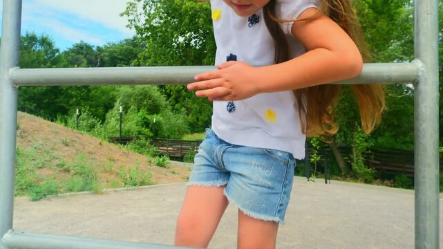 Sporty child girl doing morning workout on street sports ground. Fitness workout. a healthy family. street sports ground in a city park in casual clothes. Street workout