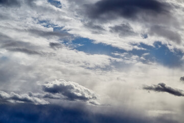 Obraz premium Sunlight filtering through stratus clouds in soft focus, with a blurred sky background, indicating improving weather and a change in weather during autumn.
