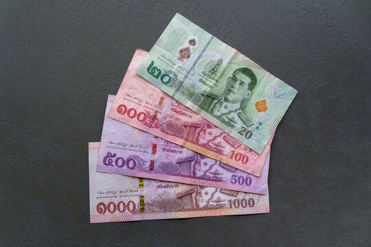 Thai Baht Banknotes on Table. Close-up of Thai Baht banknotes spread on a table, highlighting the currency.