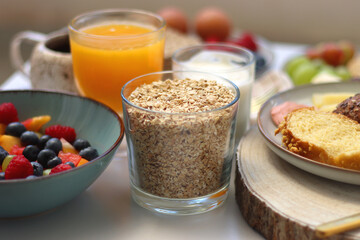 Assortment of various breakfast foods and drinks on the white table. Selective focus.