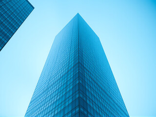 Modern skyscraper reaching toward the blue sky in an urban setting during daylight