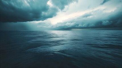 Ominous dark clouds looming over a calm ocean just before a storm