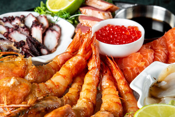 Assorted fresh seafood platter with shrimp, salmon, squid, and caviar garnished with lime.