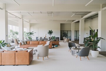 Contemporary Office Lounge Area. A sleek and modern office lounge featuring comfortable gray seating, lush green plants, and elegant lighting.