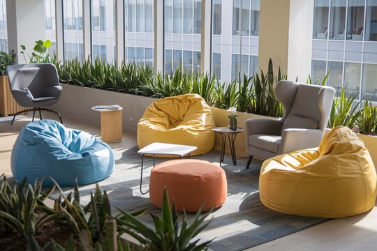 A bright and airy modern office lounge features comfortable beanbag chairs in various colors, stylish armchairs, and a lush, vibrant planter creating a relaxing and productive workspace.  - Powered by Adobe