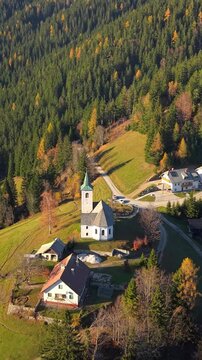 Vertical footage of Church Sveti Duh in Kamnik-Savinja Alps region on a sunny autumn day in Solcava, Slovenia