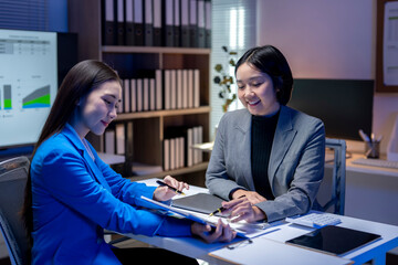 Asian businesswomen working late having business meeting in office