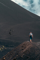 Man tourist with backpack getting lost on active stratovolcano . Travel and sightseeing journey concept.