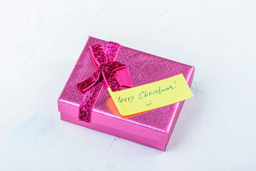 Pink gift box with handwritten note Merry Christmas.