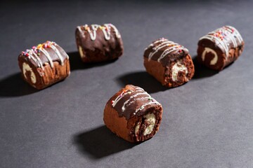 Chocolate roll cake with fresh cream isolated on dark background. chocolate swiss roll cake.