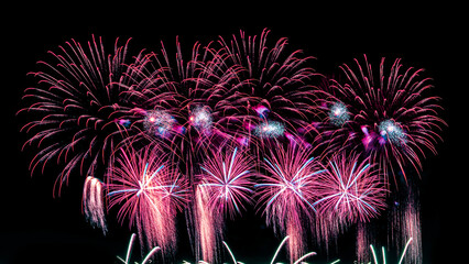 Colorful celebration fireworks isolated on a black sky background.