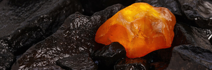 Close-up of translucent yellow and red amber on stone and wood