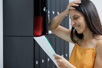 Woman looks at the correspondence in her mailbox and receives the long-awaited notifications,...