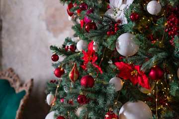 Christmas ornaments in red and white colors. Living room in dark colors,The interior is decorated with garlands and Christmas tree. Modern style. Cozy Christmas home interior.