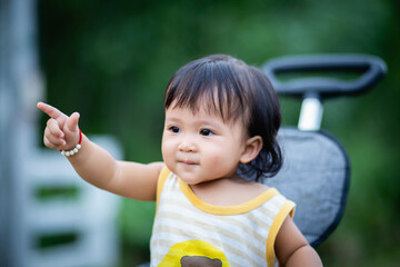 Young asian woman mother, walking with baby stroller in park