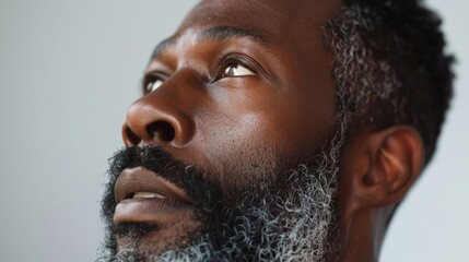 Obraz premium Elderly man focused on skincare and cosmetics for refreshed and glowing skin. Portrait of a bearded male against a neutral background for beauty treatment